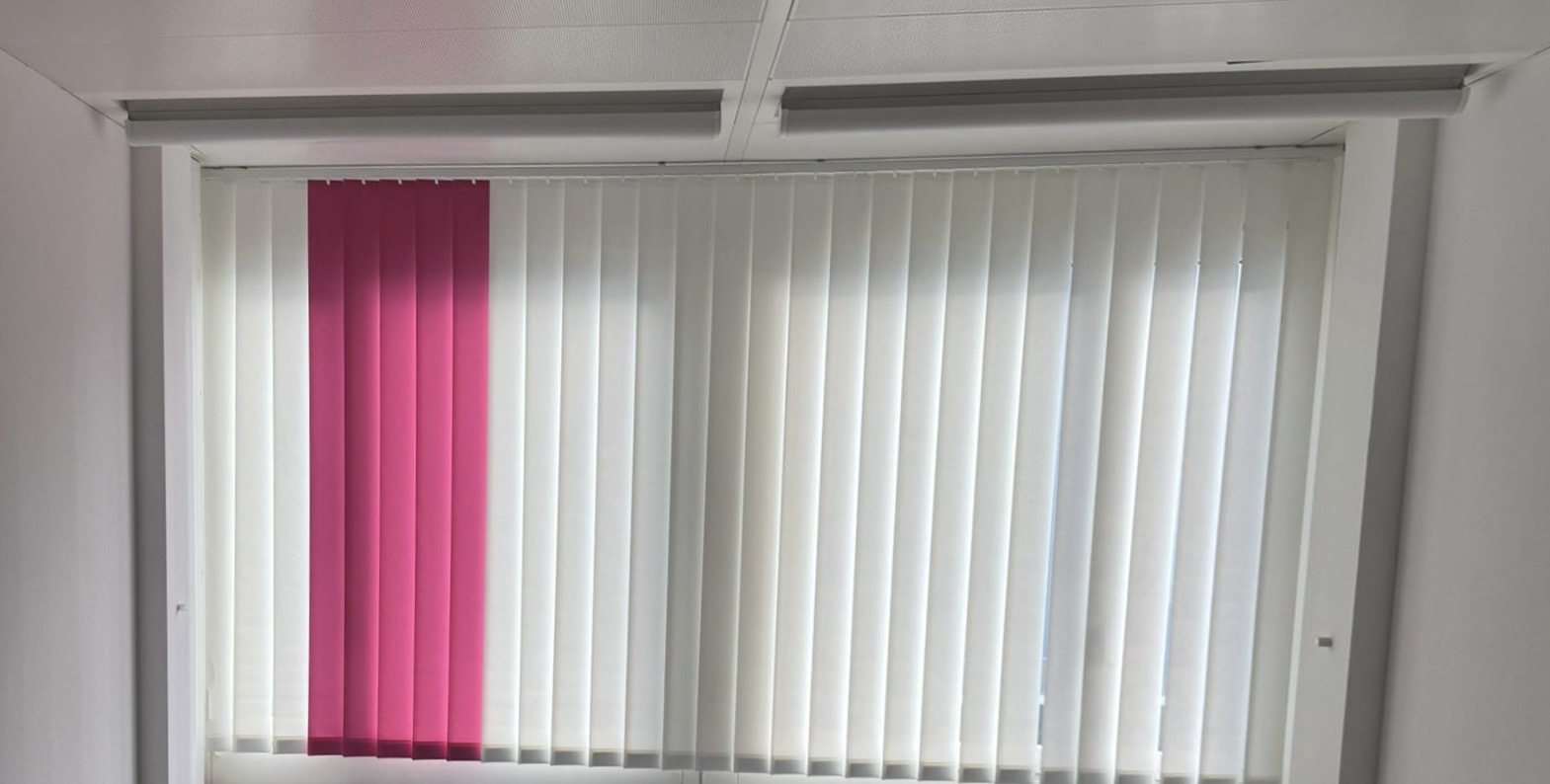 Innen montierter Lamellenvorhang vor einem Fenster