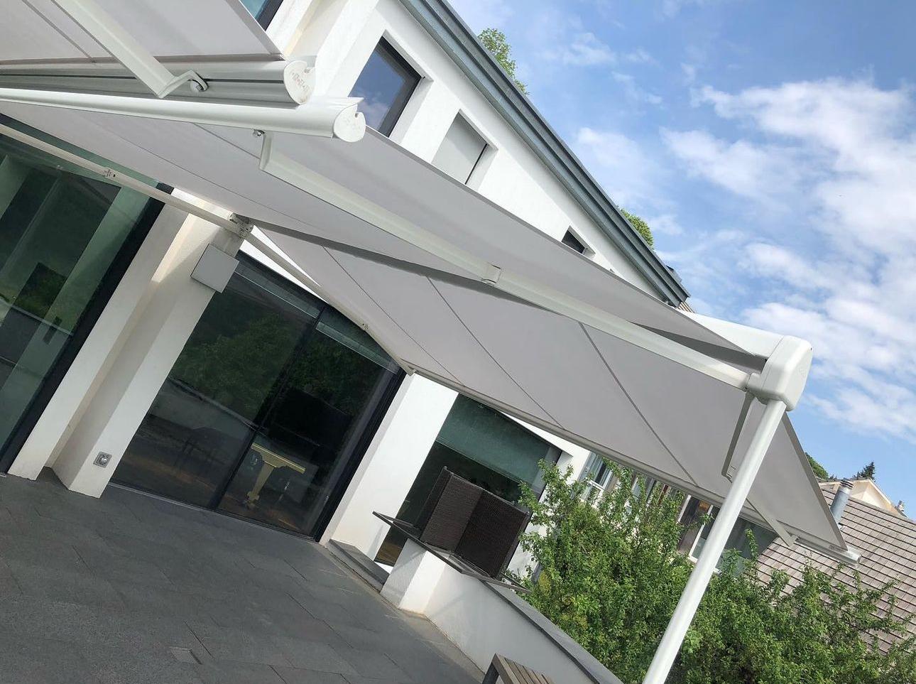 Markise an einer Glasfront mit weissem Gestell